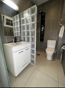 Un baño con un lavabo blanco y un inodoro. en MC Home, en Yaoundé