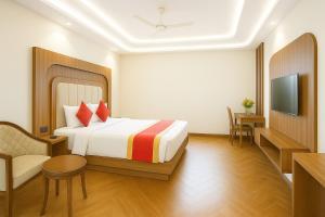 una habitación de hotel con una cama y un televisor en OPO Essential SKYNEX AEROCITY,Free airport Pickup and Drop, en Nueva Delhi