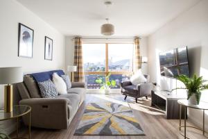 a living room with a couch and a chair at Stylish 2-Bed Penthouse Sleeps 6 Central Location in Belfast