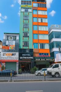 a tall building with many signs in front of it at Quỳnh Hương Hotel Phú Nhuận in Ho Chi Minh City