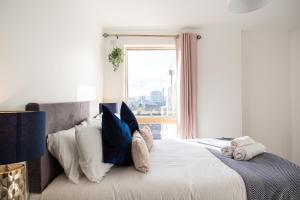 a bedroom with a bed with pillows and a window at Stylish 2-Bed Penthouse Sleeps 6 Central Location in Belfast