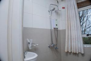 a bathroom with a shower with a toilet and a sink at Jebel Hotel & Lounge Buloba in Kampala