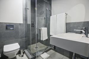 a bathroom with a sink and a toilet and a shower at The Capital Mbombela in Nelspruit