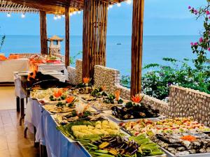 una tavola imbandita con l'oceano sullo sfondo di Rock Water Bay Beach Resort & Spa a Xóm Tram