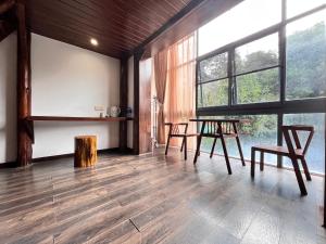 um quarto com uma mesa, cadeiras e janelas em 张家界畔山驿栈 em Zhangjiajie mais 13 fotografias