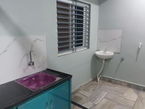 une salle de bain avec un lavabo et des toilettes et une fenêtre dans l'établissement Msquare guest room, à Godāvari