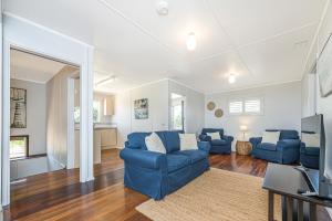a living room with blue couches and a television at Ocean Moore - Uninterrupted Ocean Views in Guilderton