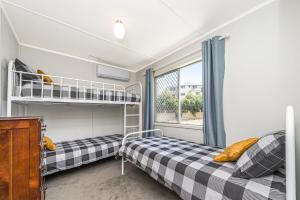 two bunk beds in a room with a window at Ocean Moore - Uninterrupted Ocean Views in Guilderton