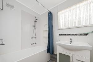 a white bathroom with a sink and a tub and a shower at Ocean Moore - Uninterrupted Ocean Views in Guilderton +26 photos