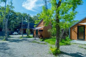 a house in the woods with a tree at HOTEL BOTH in Shari