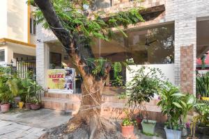 a tree in front of a building with potted plants at Collection O Biswa Bangla Convention Centre Kolkata Formerly Atithya Inn in New Town