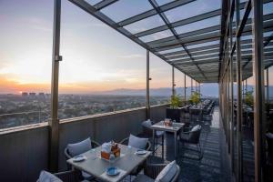 a restaurant with tables and chairs on a balcony at Courtyard by Marriott Siliguri in Siliguri