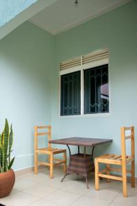 a table and chairs in a room with a window at Go Culture Africa in Entebbe +6 photos