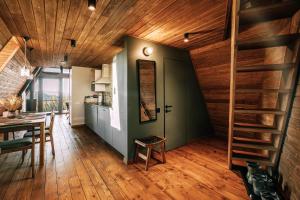 a kitchen and dining room with wood ceilings and a staircase at УЛІС Ворохта in Vorokhta
