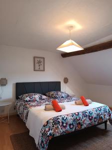 ein Schlafzimmer mit einem großen Bett mit orangefarbenen Kissen darauf in der Unterkunft La grande maison berrichonne in Aigurande