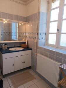 ein Badezimmer mit Waschbecken und Spiegel in der Unterkunft La grande maison berrichonne in Aigurande