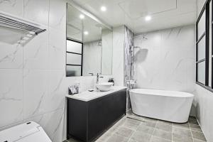 a white bathroom with a tub and a sink at Hoteld Benikea in Osan +23 photos