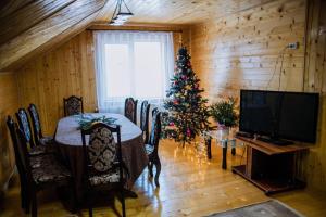 un comedor con un árbol de Navidad y una mesa en Світанок у горах, en Verkhniy Yasenov