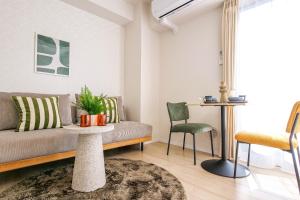 una sala de estar con un sofá, una mesa y sillas en Mr Kintaro Hotel Kinshicho, en Tokio