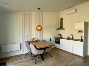 a kitchen with a wooden table and some chairs at Farmhouse Bintje met Airco in Westdorpe