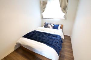 una piccola camera con un letto di fronte a una finestra di Villa de Mui nago Kaula D a Nago