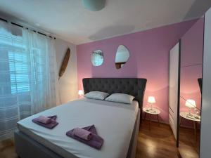 a bedroom with a large bed with purple walls at Villa Last Chance, Brač in Povlja +17 photos