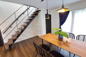 una sala da pranzo con un tavolo e una scala di Villa de Mui nago Kaula D a Nago
