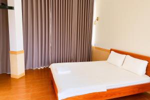 a bed with white sheets and pillows in a room at Nhật Linh Homestay in Hue +24 photos