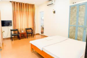 a bedroom with a bed and a table and chairs at Nhật Linh Homestay in Hue