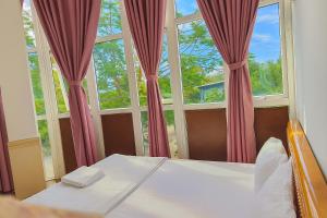 a bedroom with a bed and two large windows at Nhật Linh Homestay in Hue