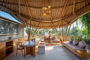 een woonkamer met een groot bamboe plafond bij Emana Bambooscape in Ubud