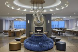 a restaurant with a blue couch and tables and a chandelier at Homewood Suites by Hilton Toronto Vaughan in Vaughan