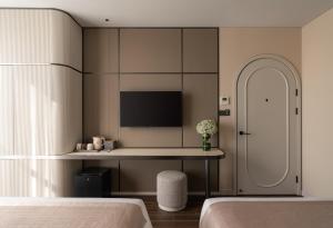 a bedroom with a bed and a desk with a tv at AMANA Hotel Phan Thiet in Ấp Bình Hưng +81 photos