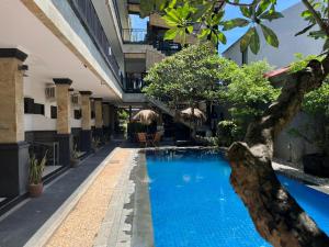 ein Swimmingpool mitten in einem Gebäude in der Unterkunft Tendan Residence Hotel in Legian