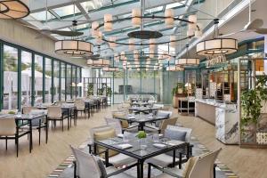a restaurant with tables and chairs and windows at Hilton Dubai Jumeirah in Dubai