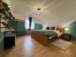 a bedroom with a bed and green walls at Grand Triplex 140m2 dans les Vosges in La Celle-sous-Gouzon