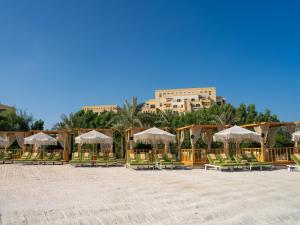 a group of chairs and umbrellas on a beach at Rixos Bab Al Bahr - Ultra All Inclusive in Ras al Khaimah
