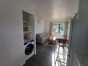 eine Küche und ein Wohnzimmer mit Waschmaschine und Trockner in der Unterkunft Nelson Road Apartment in Gisborne + 6 Fotos