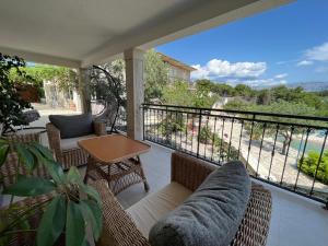 a balcony with chairs and a table and a view at Villa Last Chance, Brač in Povlja
