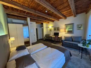 a bedroom with two beds and a living room with a couch at The Golden Wheel Hotel in Prague
