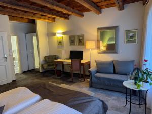 a living room with a bed and a desk with a computer at The Golden Wheel Hotel in Prague