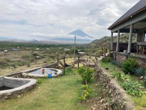 a person standing in a pool of water in a yard at Lake Natron Maasai Guesthouse in Mtowabaga +42 photos