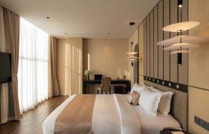 Ấp Bình HưngにあるAMANA Hotel Phan Thietの大きな白いベッドと机のある寝室 +80枚の写真