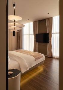 Ấp Bình HưngにあるAMANA Hotel Phan Thietの大きなベッドと薄型テレビのある寝室