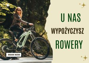 a woman riding a bike on a road at Willa Marianna in Lądek-Zdrój