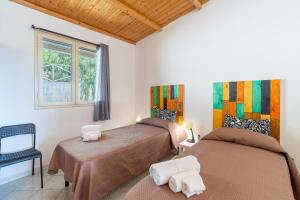 a bedroom with two beds and a window at Fiumara Val Di Noto Country Rooms in Noto