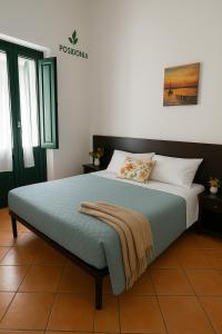 萨普里Hotel Poseidonia的卧室里有一张床，床上有一条毯子