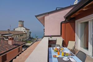 Una mesa con platos de comida en un balcón. en Appartamenti La Torre, en Lazise