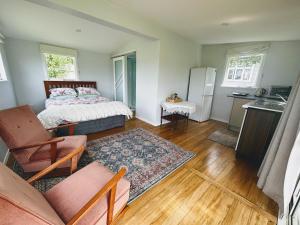 Un pequeño dormitorio con una cama y una cocina. en Peaceful private and semi rural, en Marton