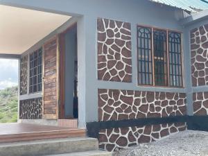 a house with a wooden door and windows at Lake Natron Maasai Guesthouse in Mtowabaga